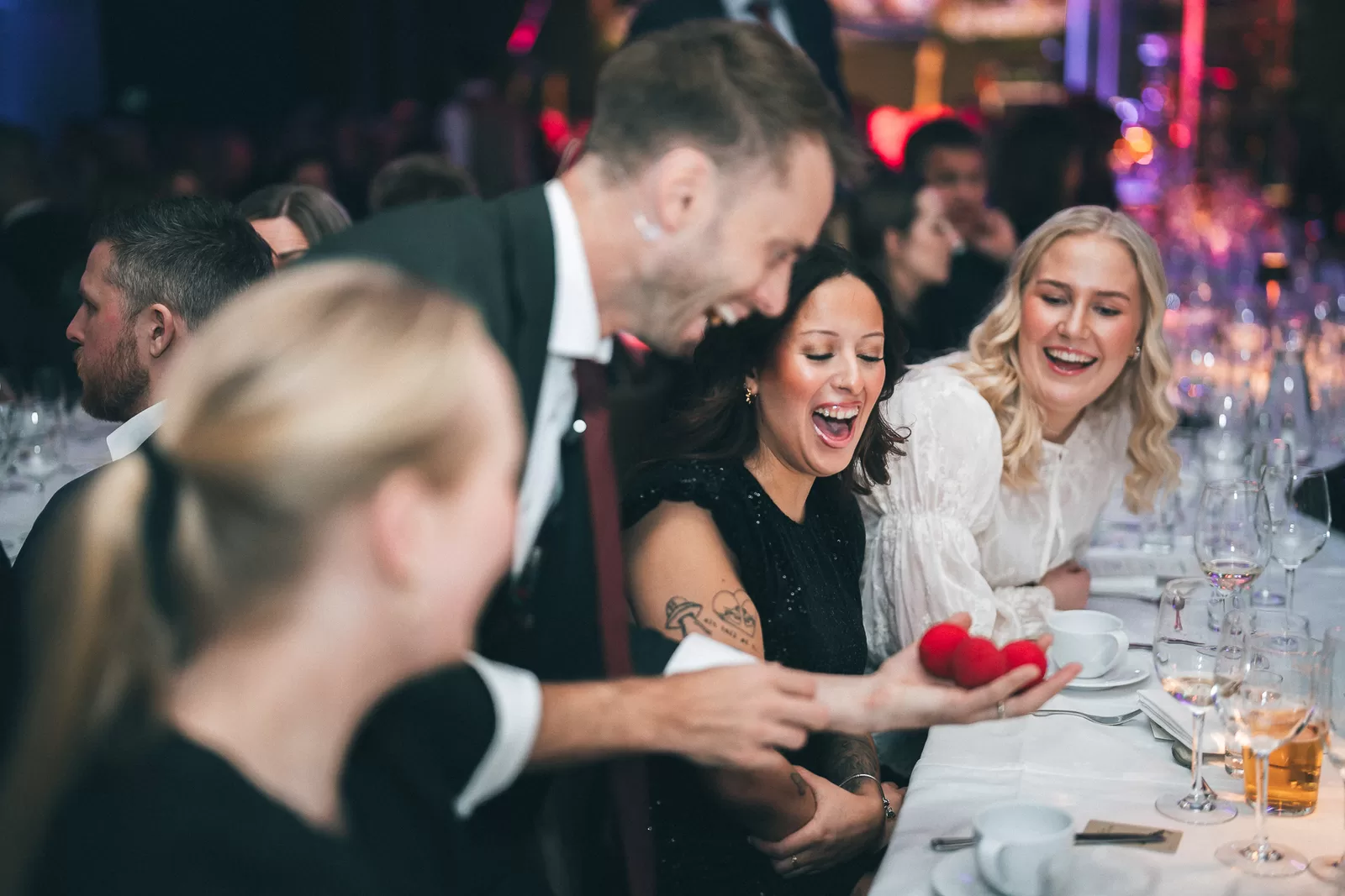 Guests laughing as a Hans Grane magic moment lands in their hands
