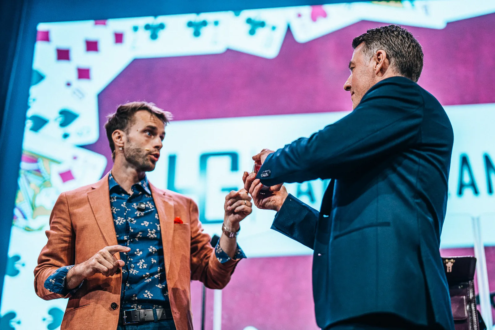 Hans Grane hosting a corporate event on stage, welcoming a guest