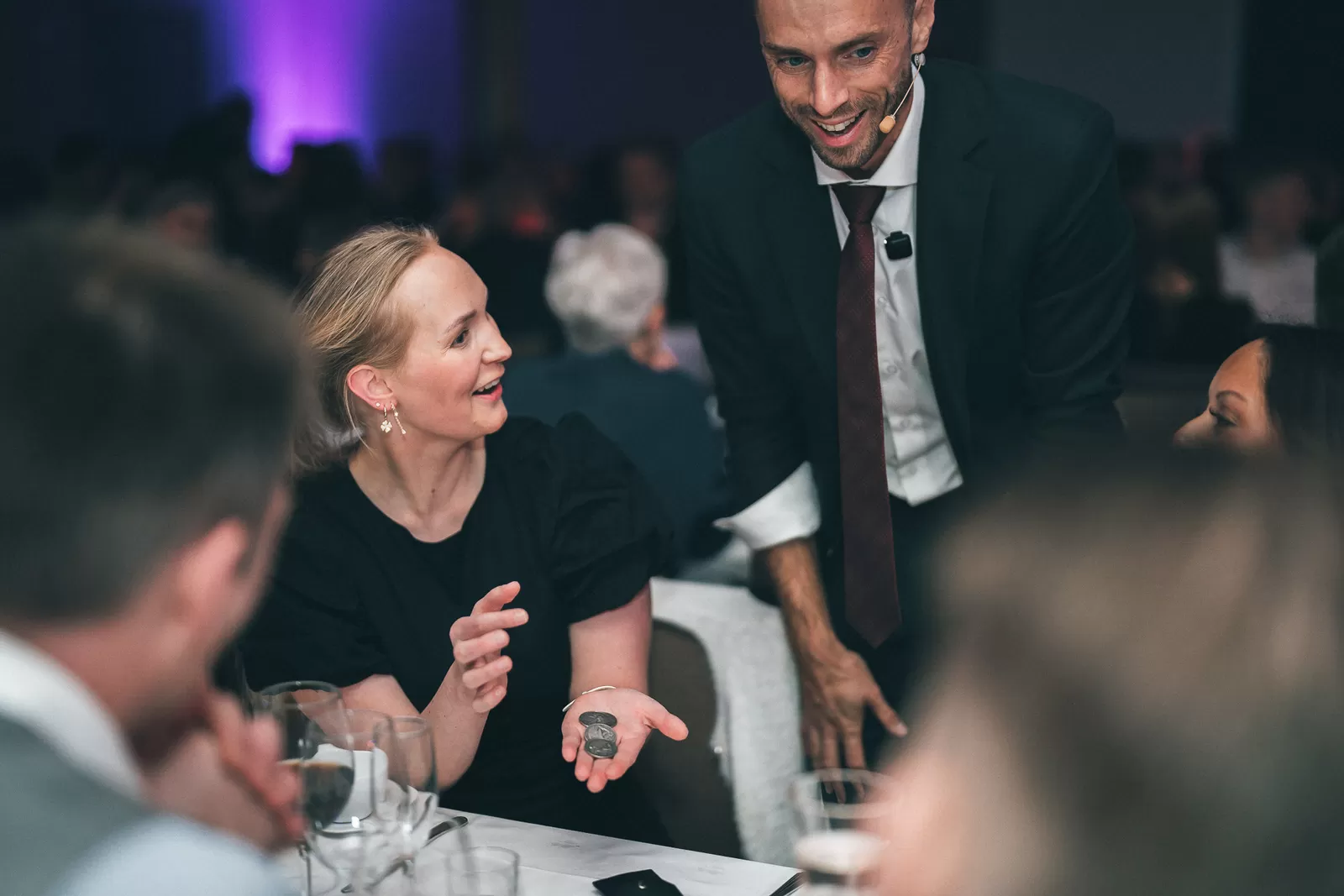 Hans Grane performing close-up coin magic at a corporate gala table
