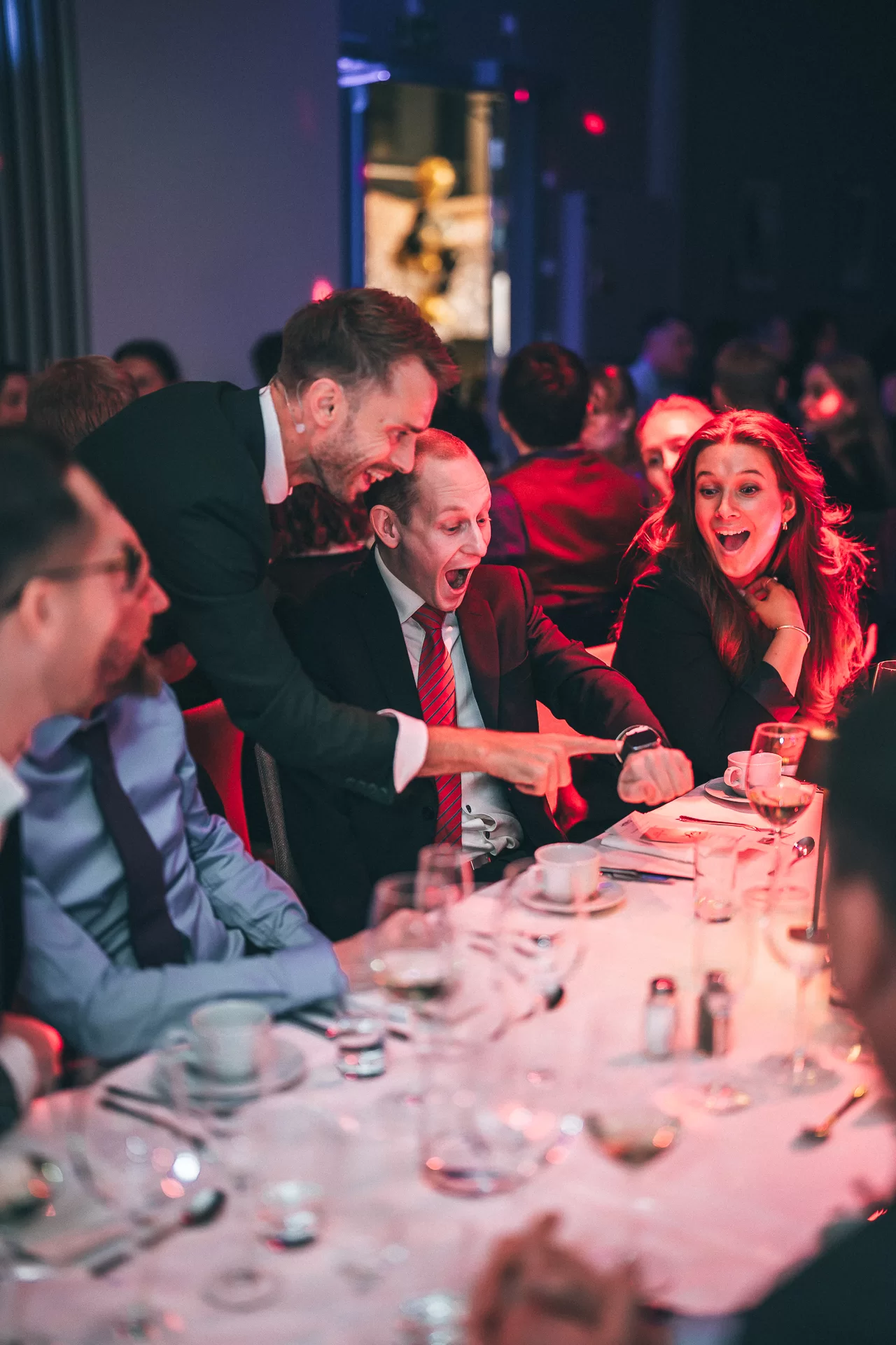 Guests reacting to Hans Grane performing close-up magic at a gala table