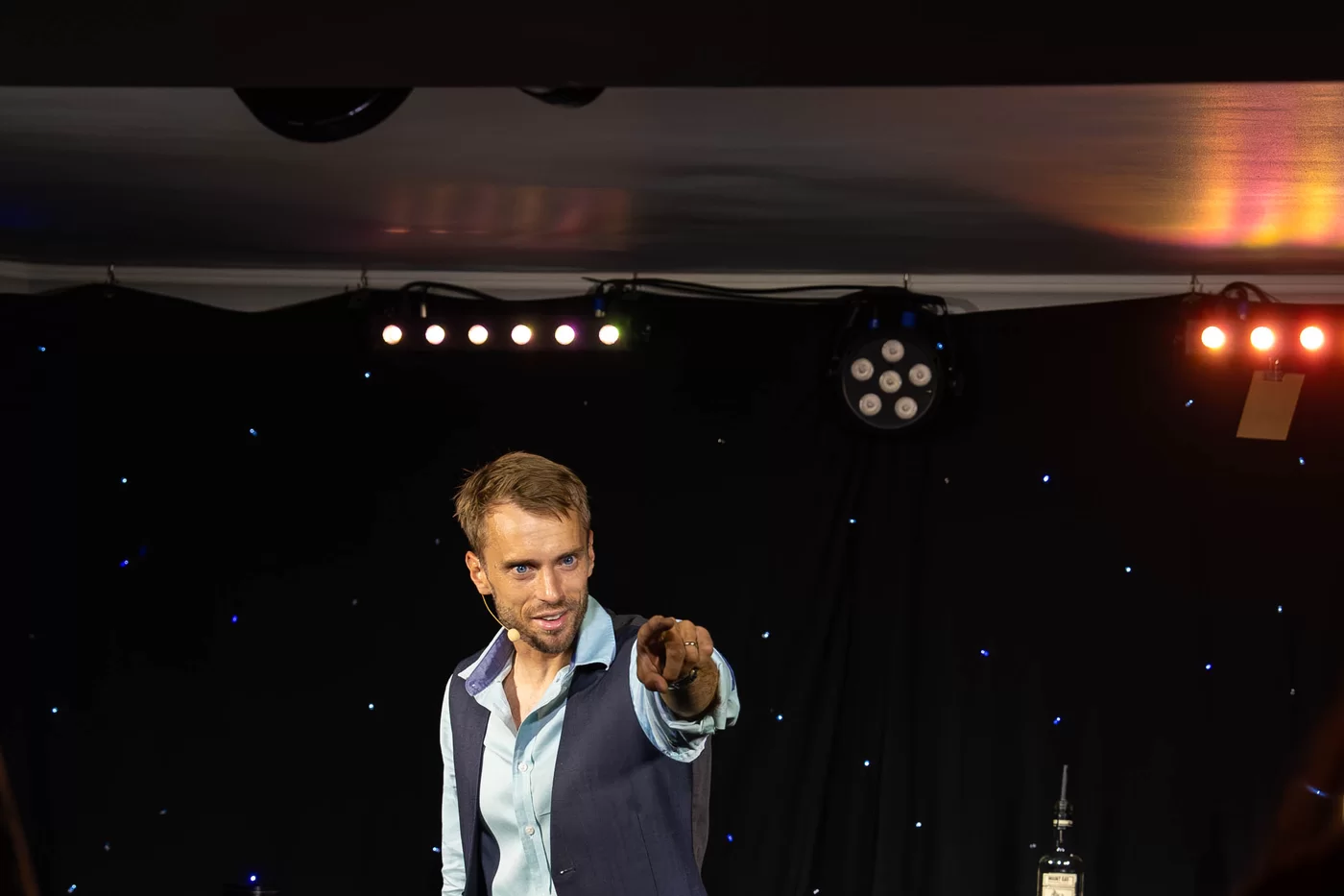 Hans Grane pointing to the audience under moody theatre lights