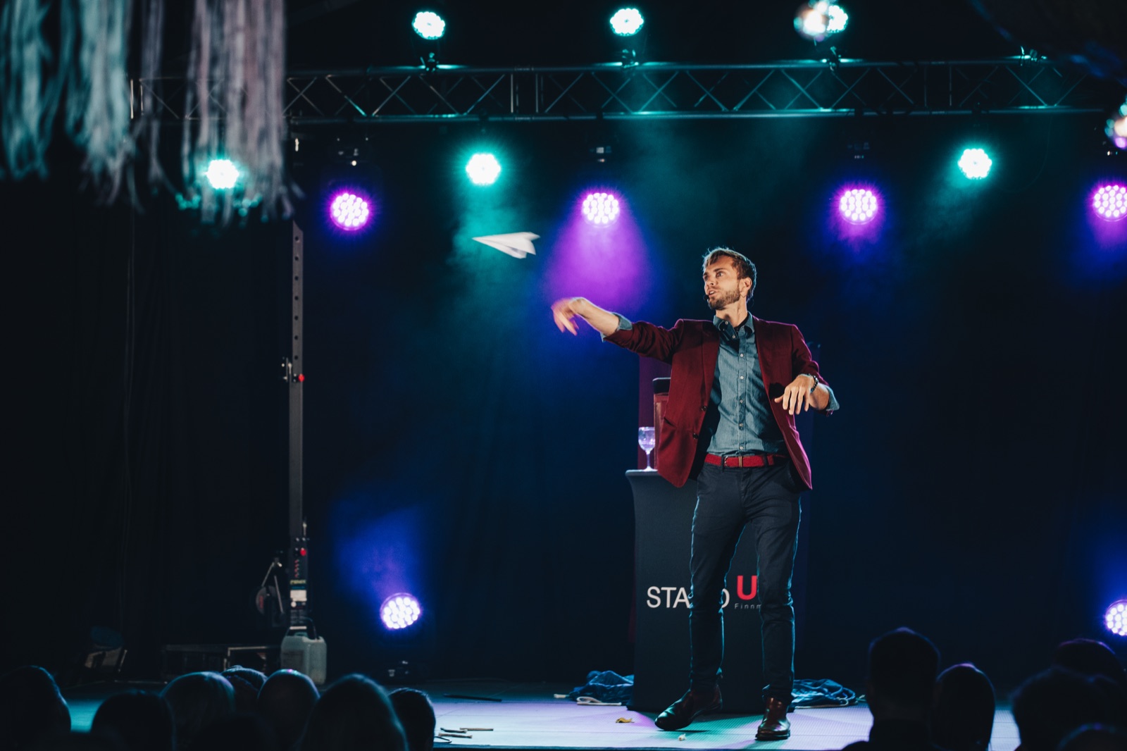 Hans Grane p&aring; scenen med et papirfly over publikum under et sceneshow