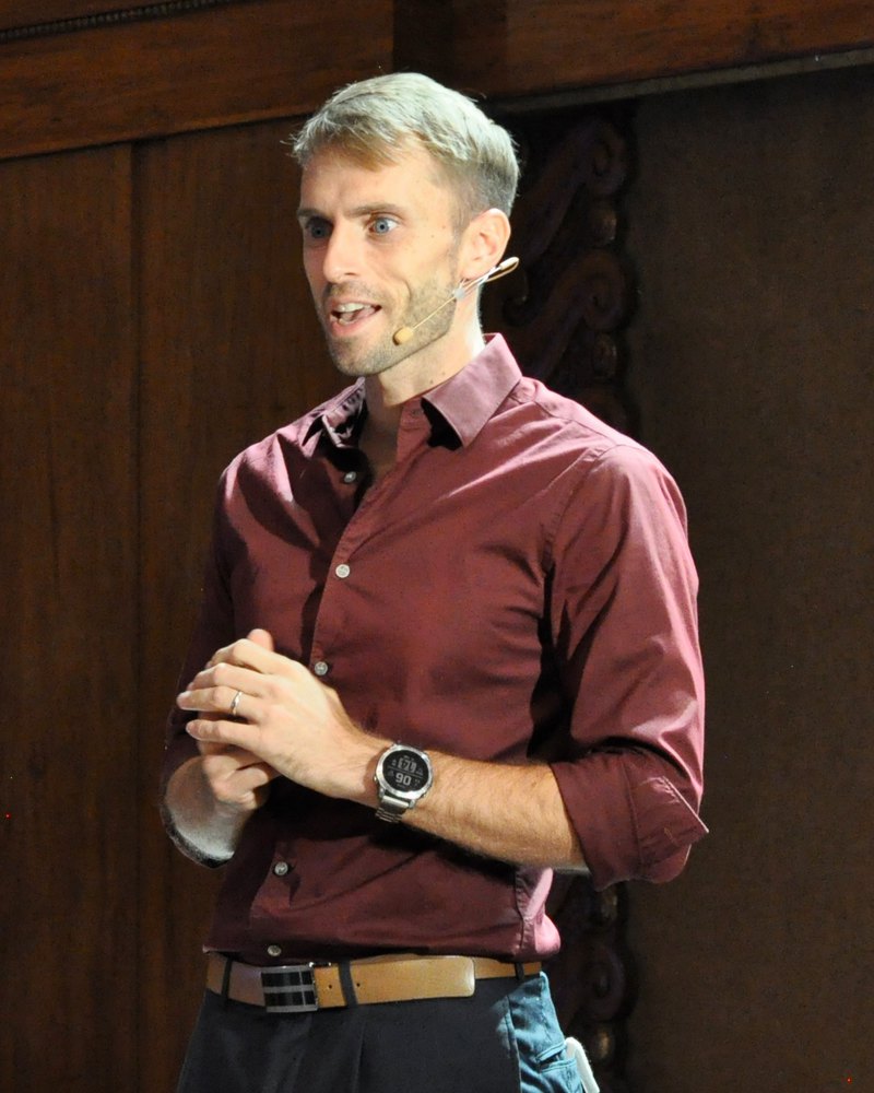Hans Grane performing comedy magic on stage at a corporate event