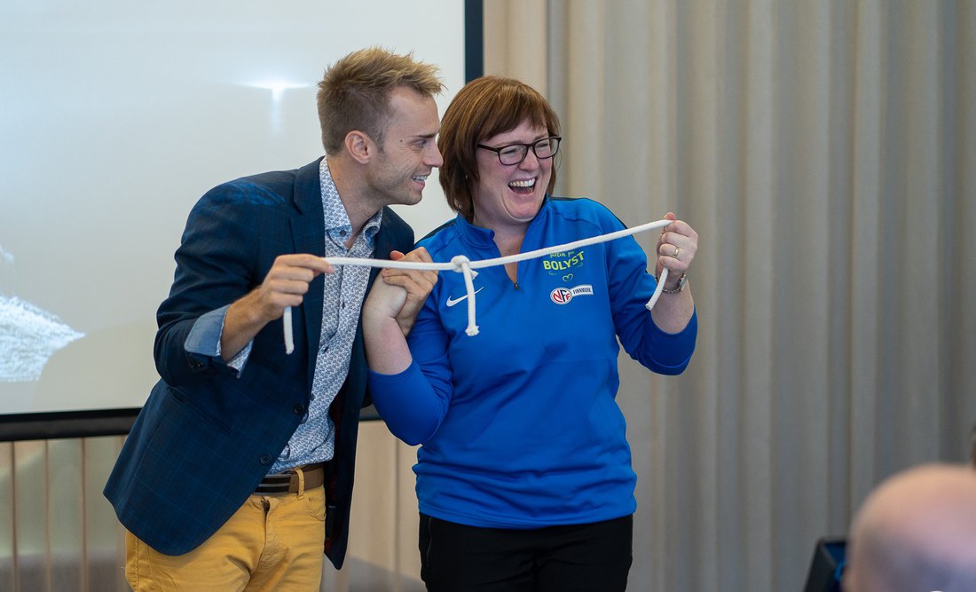 Hans Grane and a participant laughing together during a team-building magic session